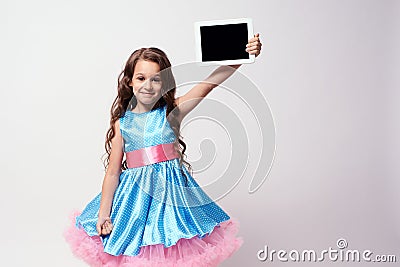 Modern technologies. Beautiful little girl. Lush blue dress Stock Photo
