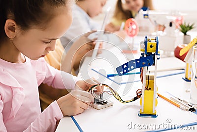 Girl building robot, working with wires in class Stock Photo