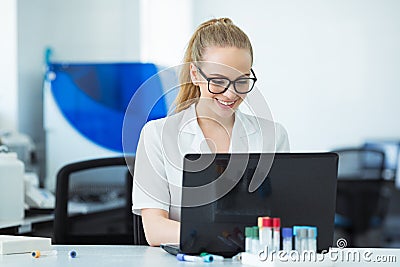 Modern technology in science. Scientist entering data of analysis or research results to laptop at laboratory. Stock Photo