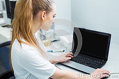 Modern technology in science. Scientist entering data of analysis or research results to laptop at laboratory. Stock Photo