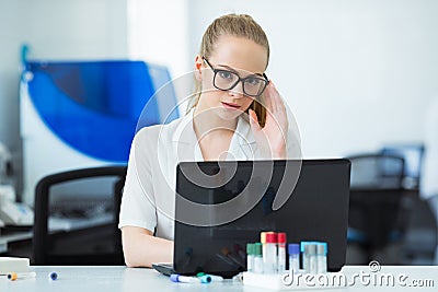 Modern technology in science. Scientist entering data of analysis results to laptop at laboratory. Stock Photo