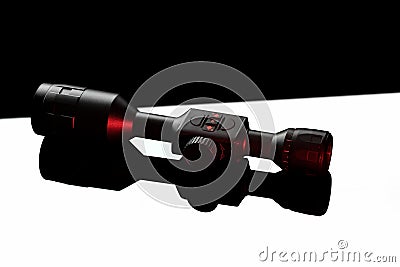 Modern telescopic sight on a smooth mirrored surface. The sight is highlighted in red. A device for shooting at long distances Stock Photo