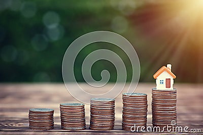 Modern tiny house on stack money coins put to a higher level. Stock Photo