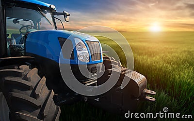 Modern tractor on a field with green wheat at sunset Stock Photo