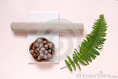 Modern trendy wellness concept with almond, natural stone plate and green fern leave . Close up, top view on neutrals tones paper Stock Photo