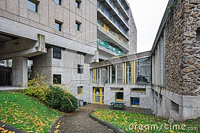 a green bench next to a cement building and stairs with yellow and blue paint Editorial Stock Photo