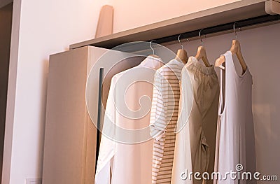 Modern walk in closets design interior with clothes hanging on rail warm tone Stock Photo