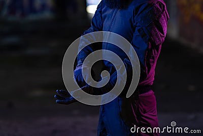 Modern warfare soldier checking navigation, time and other information on a smartwatch. Dark night black background. Stock Photo