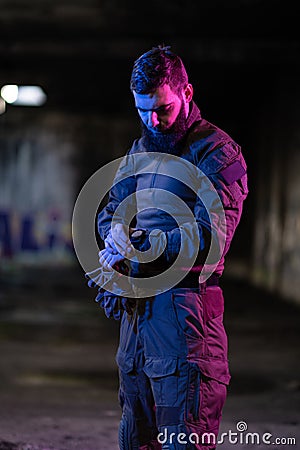 Modern warfare soldier checking navigation, time and other information on a smartwatch. Dark night black background. Stock Photo