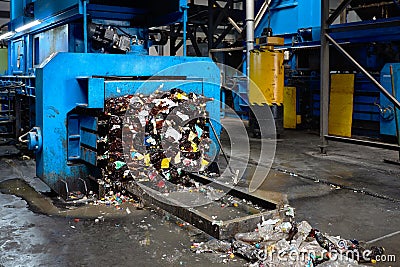 Modern waste sorting and recycling plant, hydraulic press makes wired bale from pressed PET bottles for processing and reuse of Stock Photo