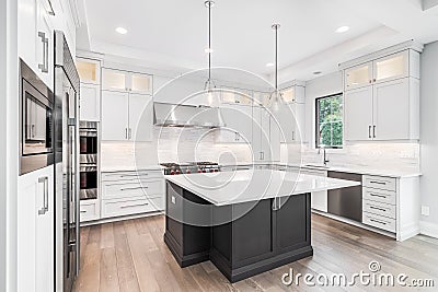 A modern white kitchen with a large grey island. Editorial Stock Photo