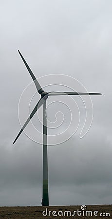 Modern windmill in broody mood. Monumental electricity wind mills in landscape. Renewable green energy. Stock Photo