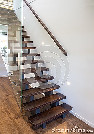 Modern wooden staircase with large thick glass balustrade Stock Photo