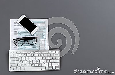 Modern work items to prepare to do income taxes on a gray table top with copy space Editorial Stock Photo