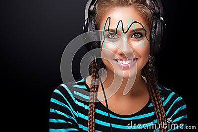 Modern young woman with art makeup enjoys listening to music in headphones. Positive emotions, leisure. Copy space. Stock Photo