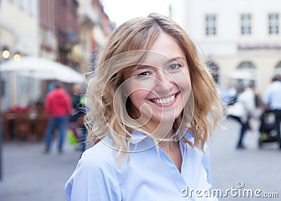 Modern young woman with curly blond hair in the city Stock Photo