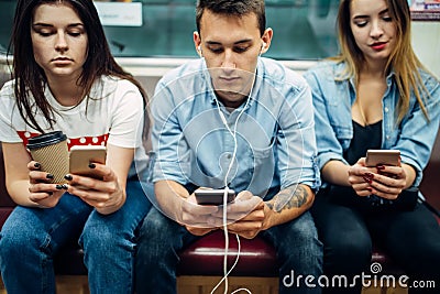 Modern youth using phones in subway, addiction Stock Photo