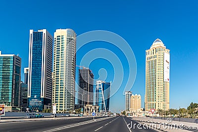 Moderns buildings under construction in downtown Doha in a blue sky day in Qatar, street perspective. Editorial Stock Photo