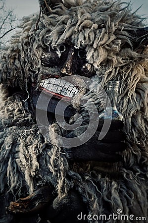 Mohacs, Baranya / Hungary - FEB 26 2017 : traditional participant called buso of the busojaras event holding a bottle of spirits Editorial Stock Photo