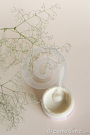 Moisturizing cosmetic cream with eucalyptus stands on neutral background with milk splash Stock Photo