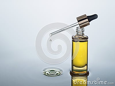 Moisturizing cosmetic oil stands on the dark water background with splash Stock Photo