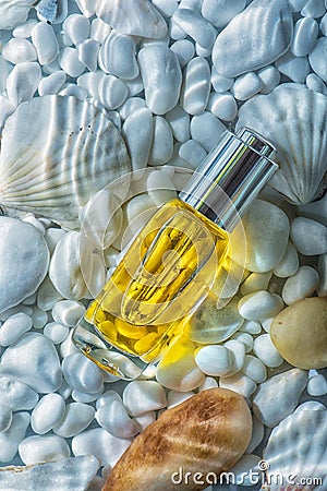 Moisturizing cosmetic oil under a layer of water on the the white stones and sea shells Stock Photo