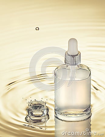 Moisturizing serum on the yellow water background with splash and drop Stock Photo