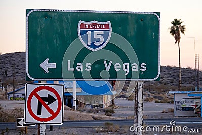 CLOSE UP: Green highway sign directs traffic across Mojave desert to Las Vegas. Stock Photo