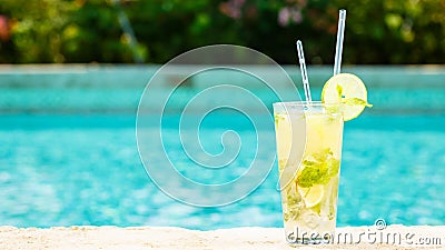 Mojito cocktail at the edge of a resort pool. Concept of luxury Stock Photo