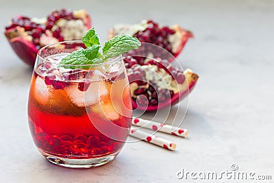 Mojito cocktail with pomegranate, mint, lemon juice and ice in a glass, horizontal, copy space Stock Photo