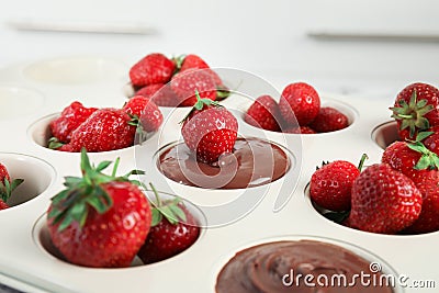 Mold with melted chocolate and strawberries, closeup Stock Photo