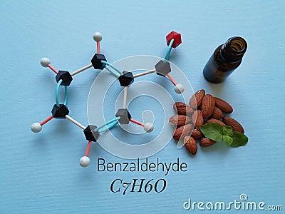 Molecular structure model and chemical formula of benzaldehyde molecule with almonds and almond oil on blue background Stock Photo