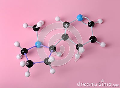 Molecule of nicotine on pink background, top view. Chemical model Stock Photo
