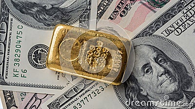Molten gold bar weighing 250 gram against the background of dollar bills Stock Photo