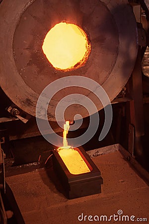 Molten gold being poured from furnace Stock Photo