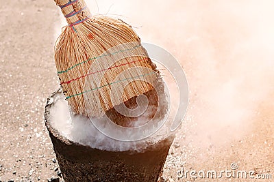 Molten hot tar in a bucket on the bricks. Roof repair tar from a bucket with a broom Stock Photo