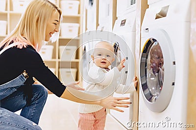 Mom and baby in the laundry take things and play Stock Photo