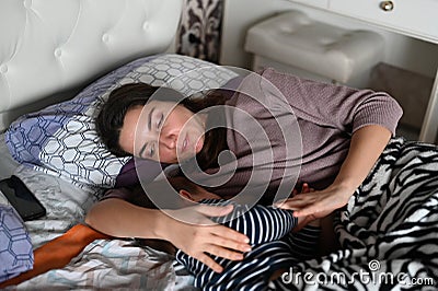 Mom and baby sleep happily. Mom smiles at her baby when sleeping. Calm dream of mother and baby Stock Photo