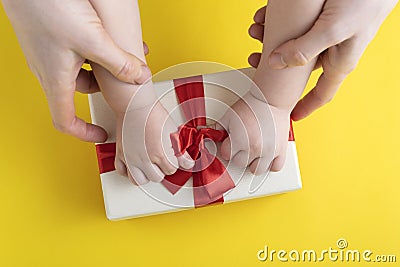 Mom and baby untie bow on the gift. Top view Stock Photo