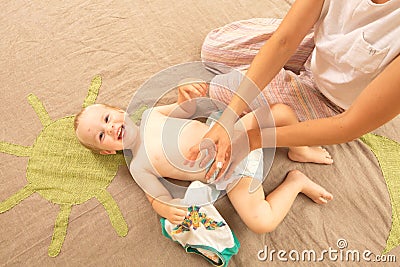 Mom change funny baby boy infant diaper Stock Photo