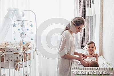 Mom changing diaper to baby Stock Photo