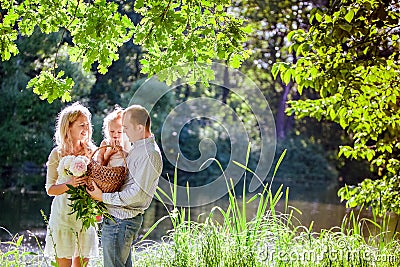 Mom , dad and daughter on the background of the forest and water Stock Photo