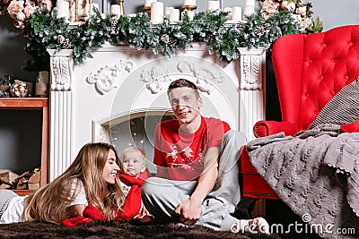 Mom, dad and little baby son . Loving family Merry Christmas and Happy New Year. Cheerful pretty people. Parents and Stock Photo