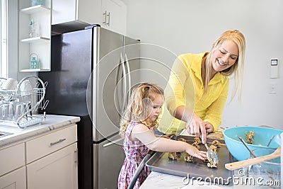 Mom and daughter baking cookies in their kitchen. Stock Photo