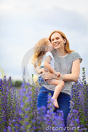 Mom and daughter in field with purple flowers Stock Photo