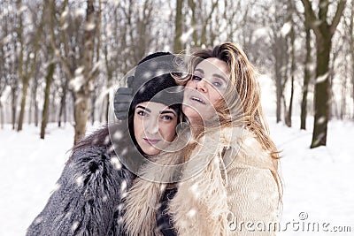 Mom and daughter hugging each with love in the snow Stock Photo