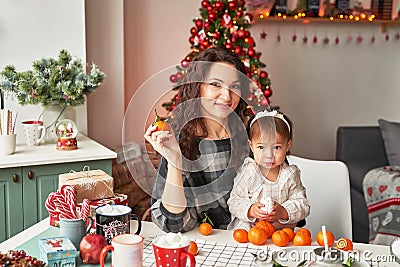 Mom and little daughter in the kitchen decorated for the new year and christmas Stock Photo