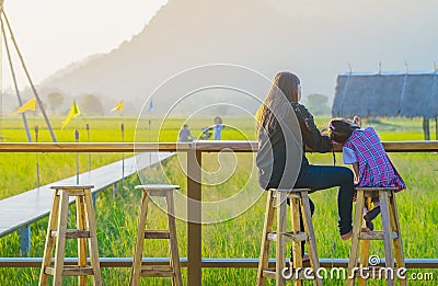 Mom and daughter sit for resting and waiting for time to take photos of the sunset on the farmer`s balcony Editorial Stock Photo