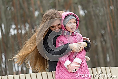 Mom and daughter are sitting on a park bench Stock Photo