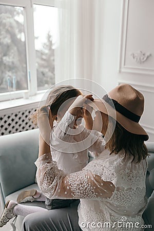 Mom and daughter in white blouses playing in the studio with daffodils. mother`s day Stock Photo